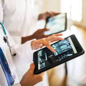 Doctors looking at tablet that show CT scans