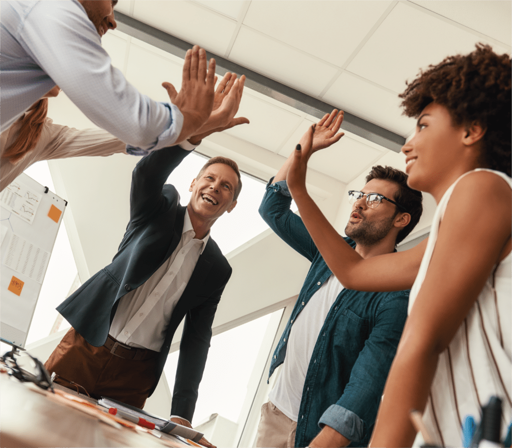 A group of office workers high five each other