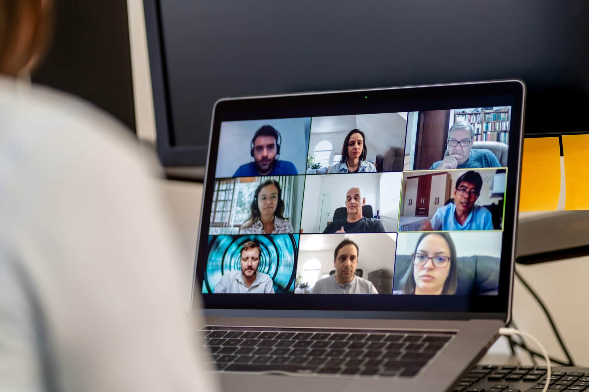 Healthcare professionals appear on a screen attending an online meeting